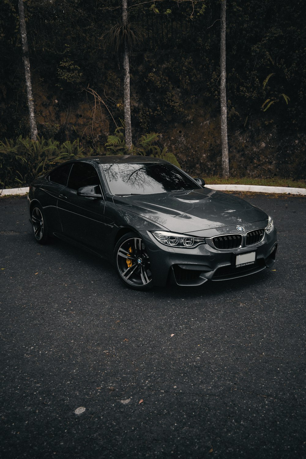 a car parked in a parking lot next to trees