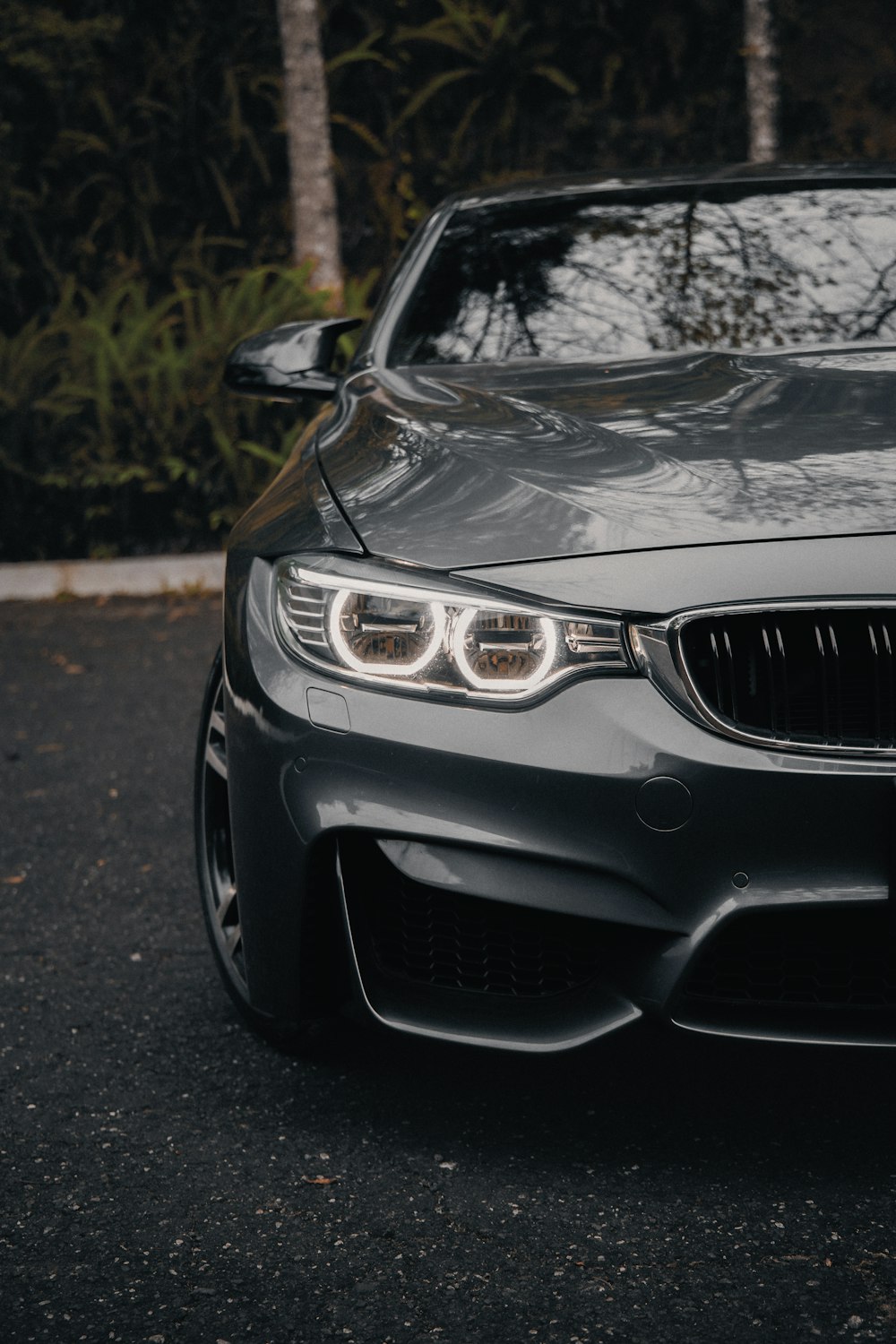 the front end of a gray car parked in a parking lot