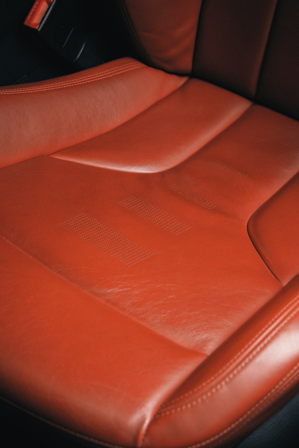 a close up of a red leather seat in a car