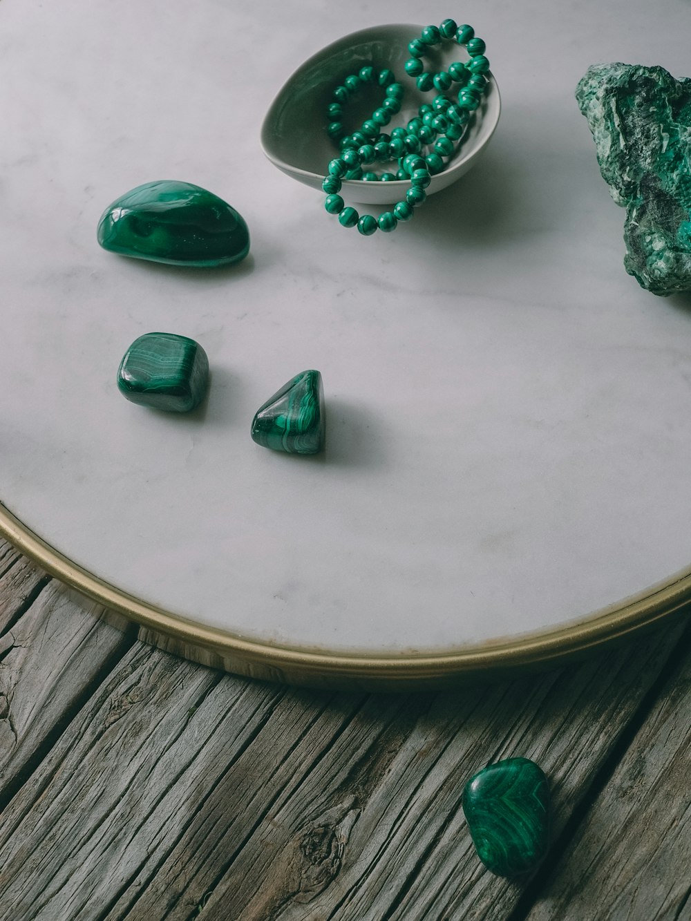 녹색 돌과 녹색 구슬 한 그릇을 얹은 테이블