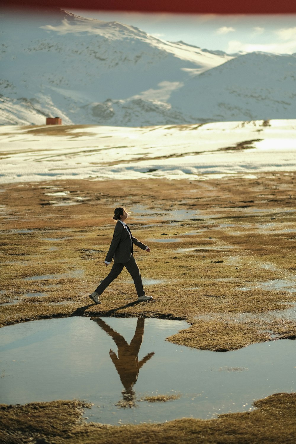 a man in a suit walking across a field