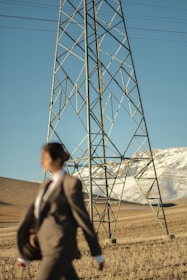 a man in a suit walking past a tall tower