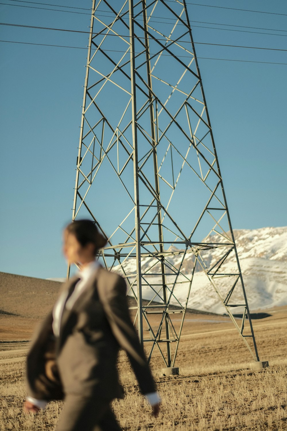 a man in a suit walking past a tall tower