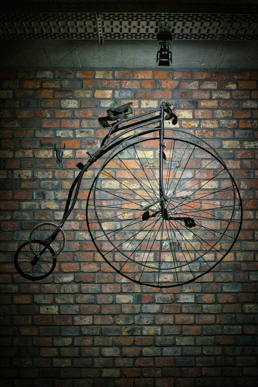 an old fashioned bicycle hanging on a brick wall