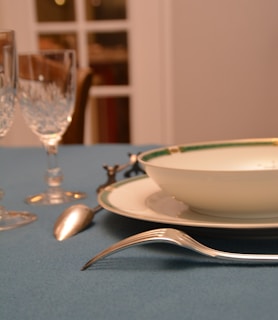 a table with a blue table cloth and silverware