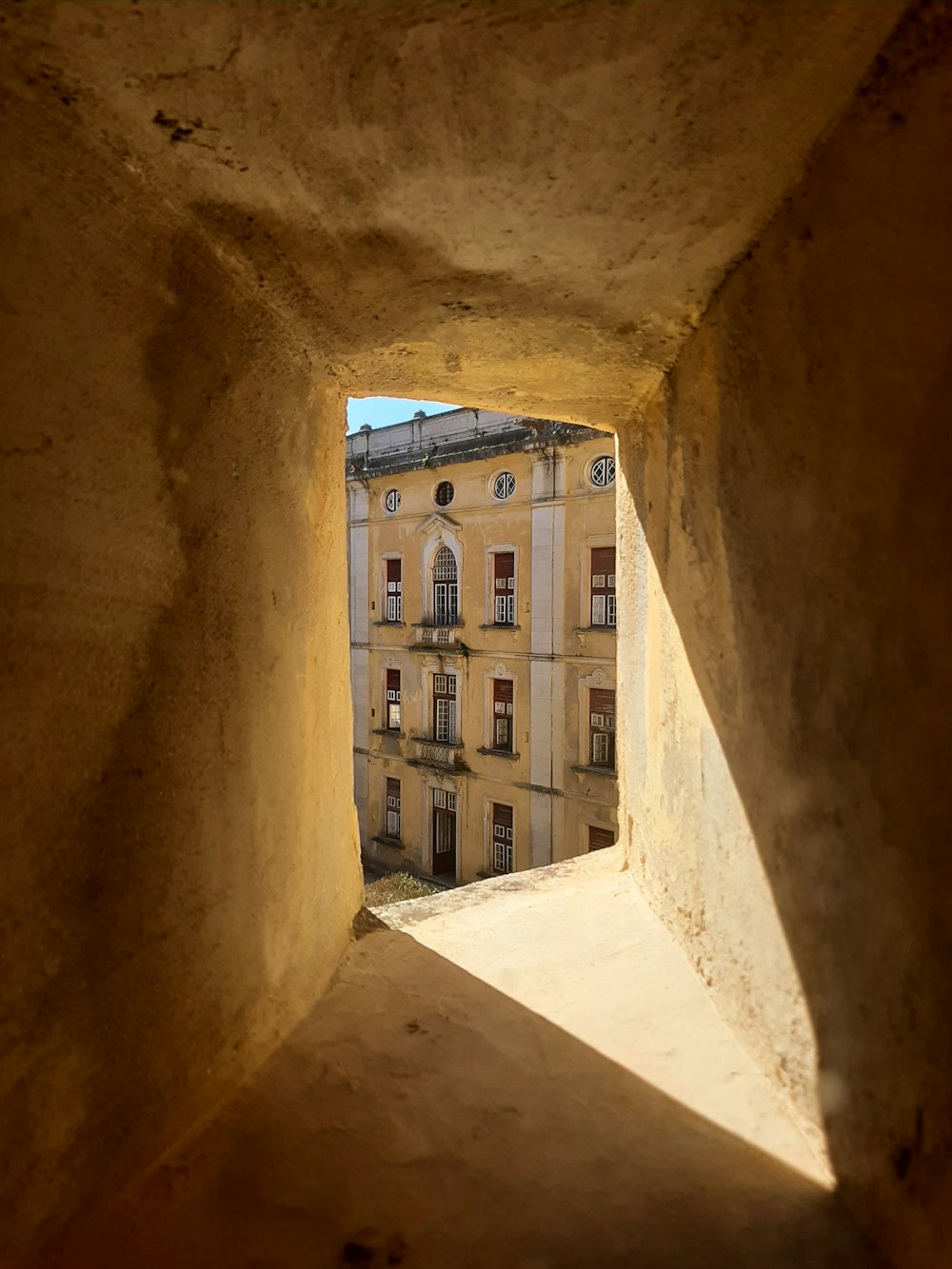 a view of a building through a hole in a wall