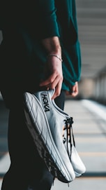 a person holding a pair of shoes in their hand
