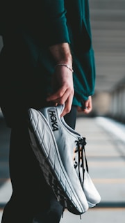 a person holding a pair of shoes in their hand