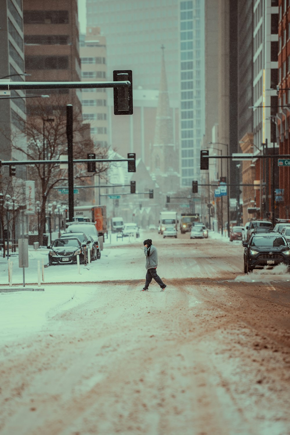 a person walking across a snow covered street