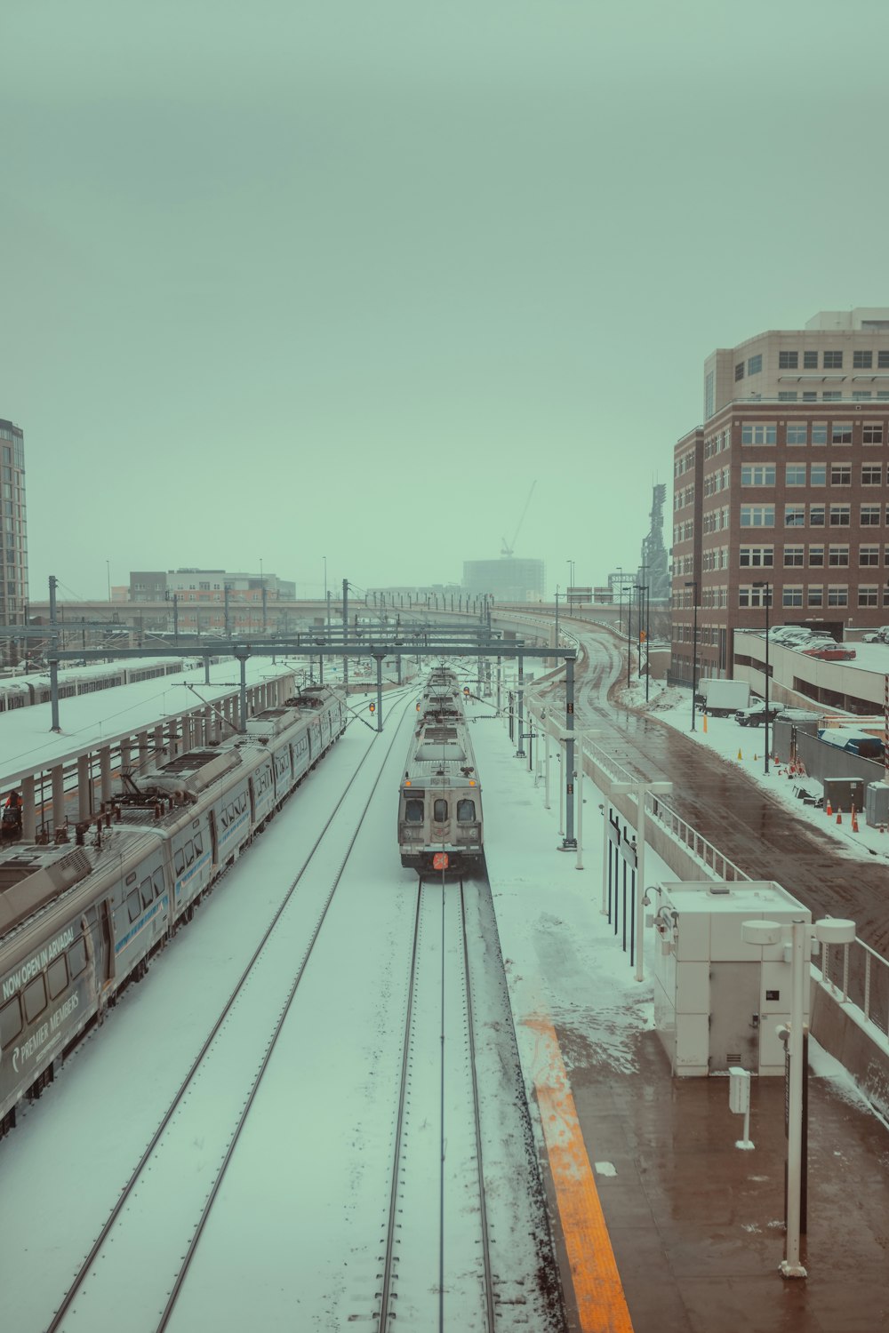 a couple of trains that are sitting in the snow