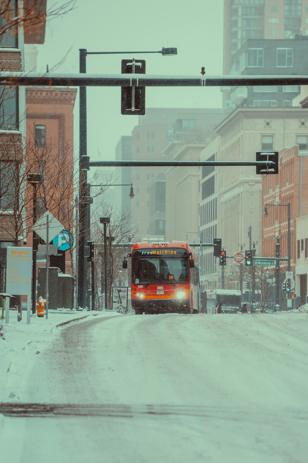 a bus driving down a snow covered street