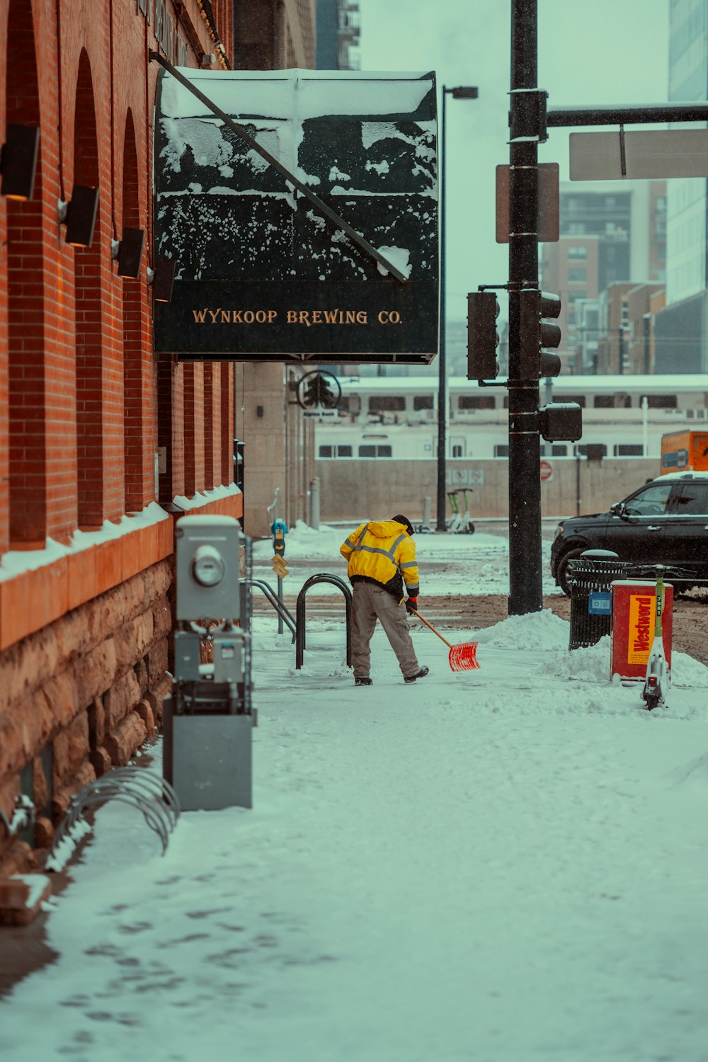 a man shoveling snow on a city street