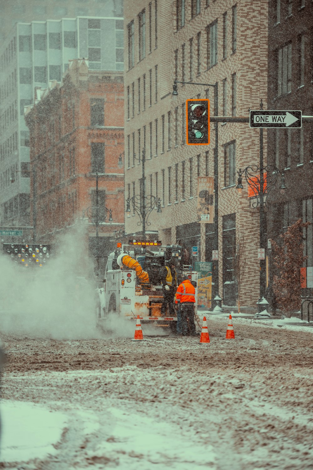 a street scene with a snow plow and traffic lights