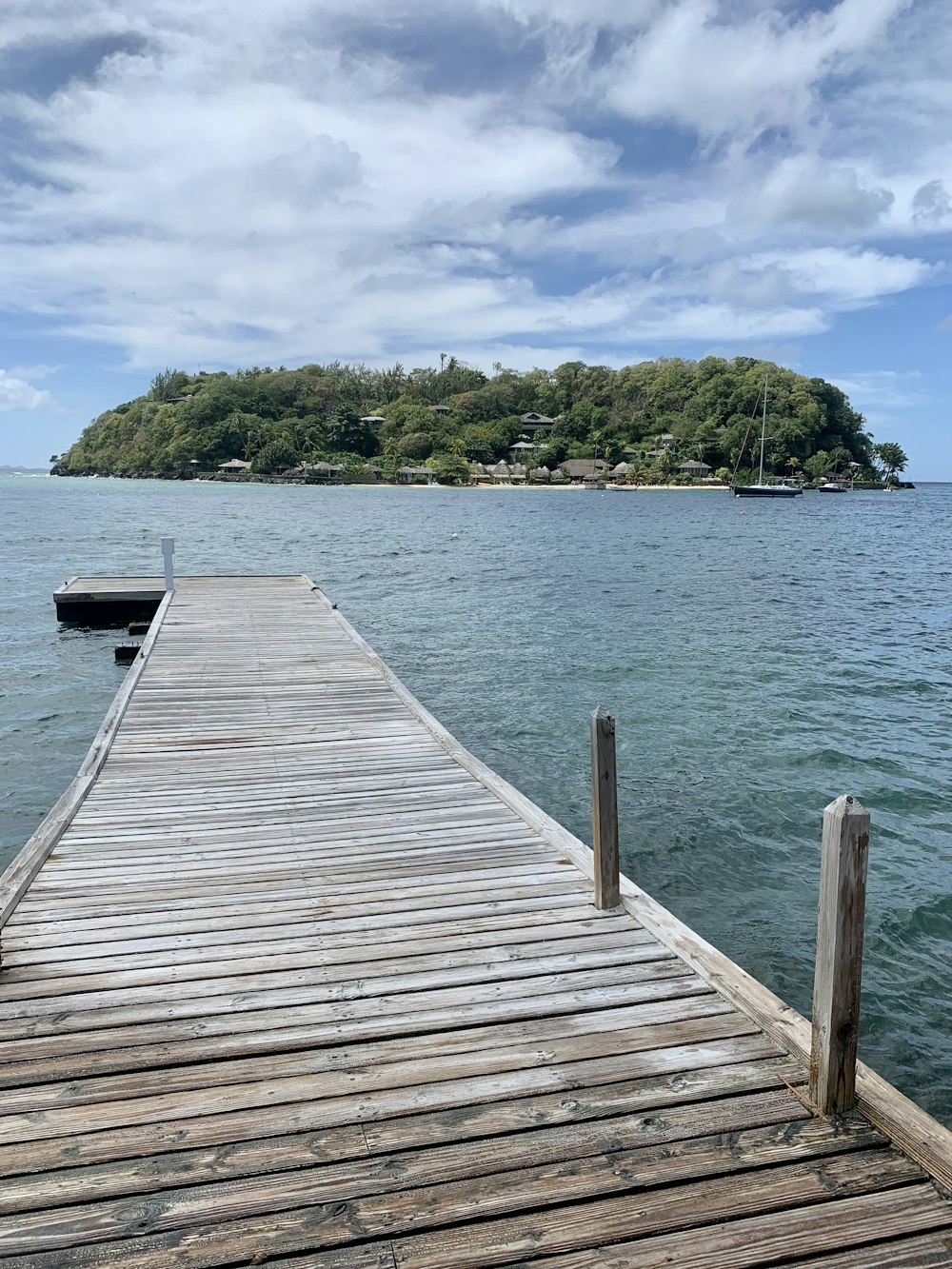 a wooden dock with a small island in the background