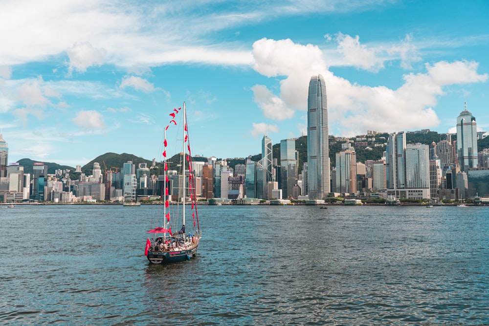 a sailboat in a body of water with a city in the background