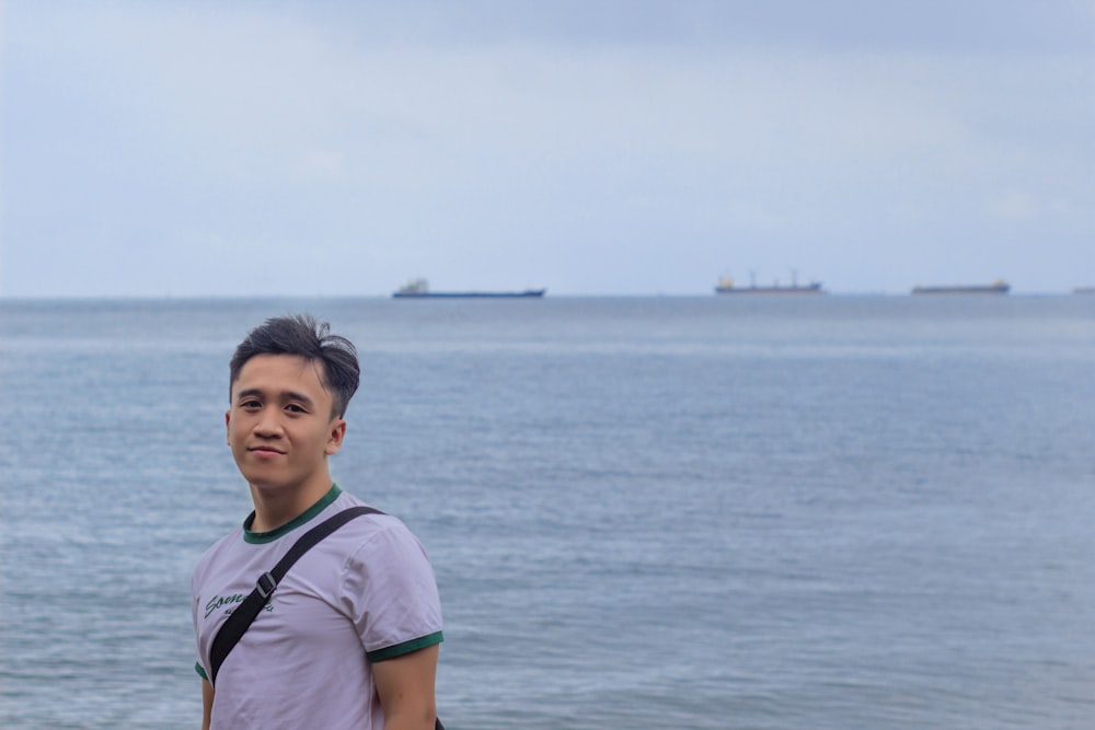 a man standing on a beach next to the ocean