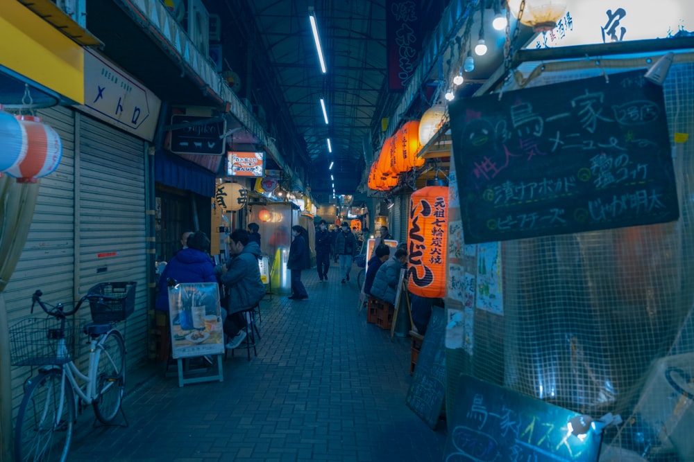 a group of people walking down a street next to shops