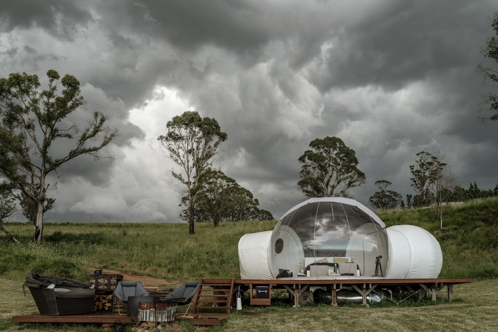 a trailer sitting in a field under a cloudy sky