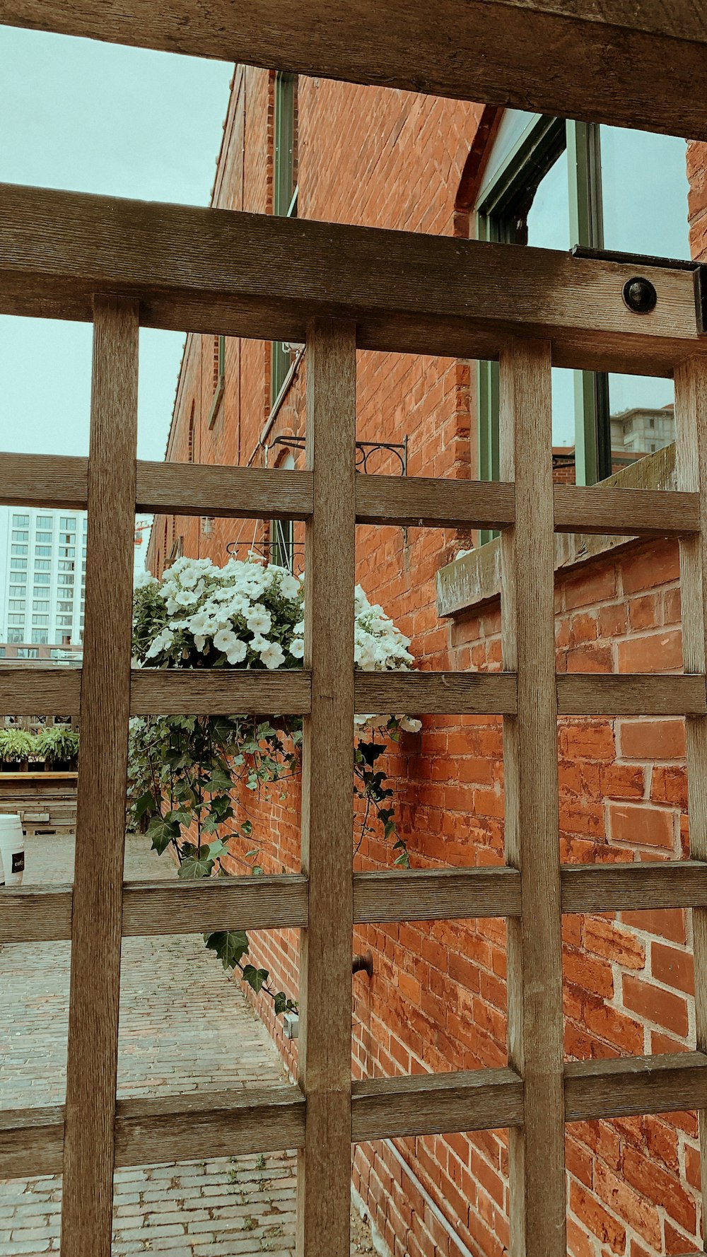 a brick building with a window and a wooden fence