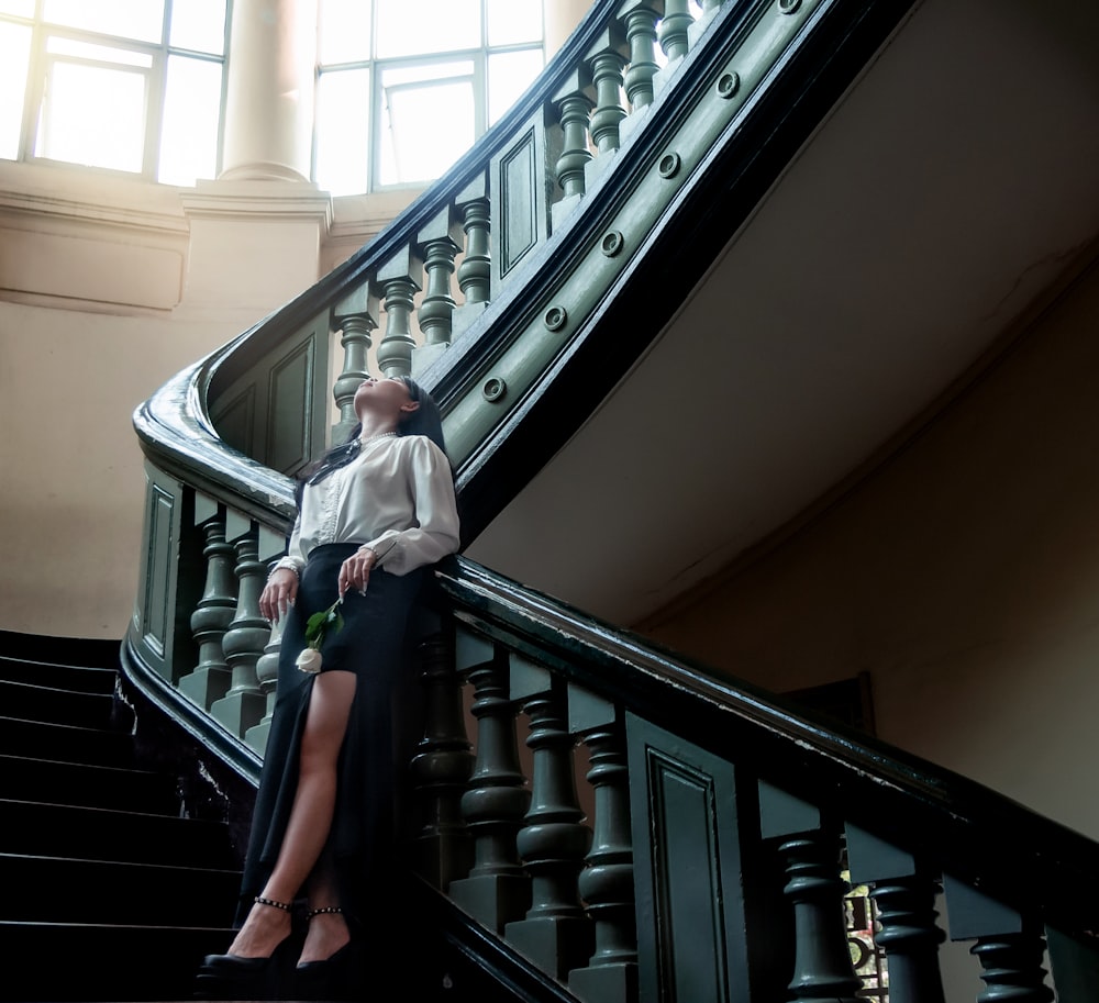 a woman is sitting on the stairs of a building