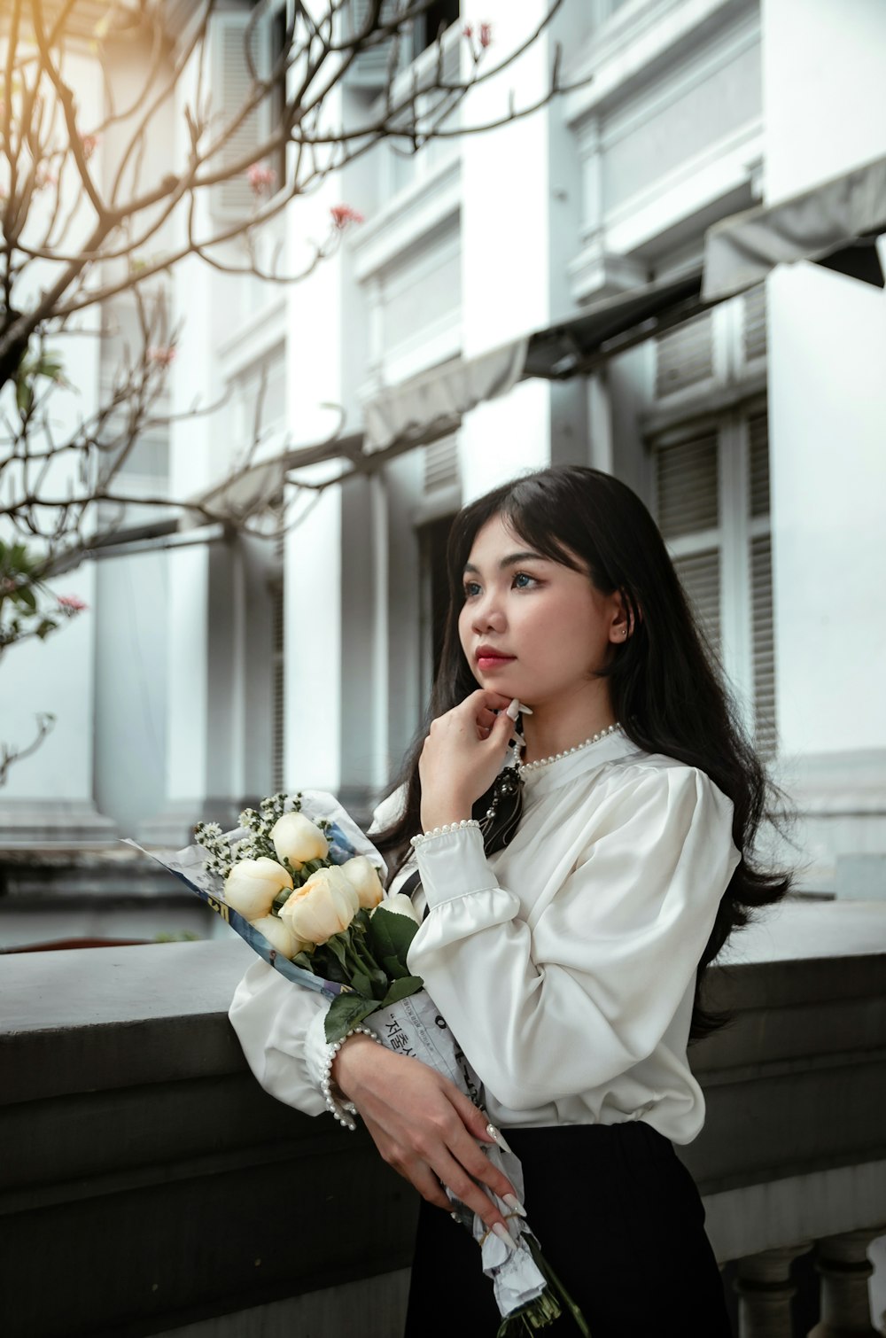 a woman holding a bouquet of flowers in front of a building
