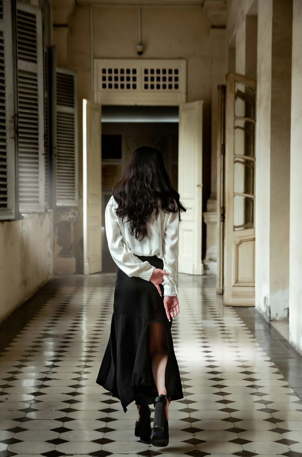 a woman in a white shirt and black skirt