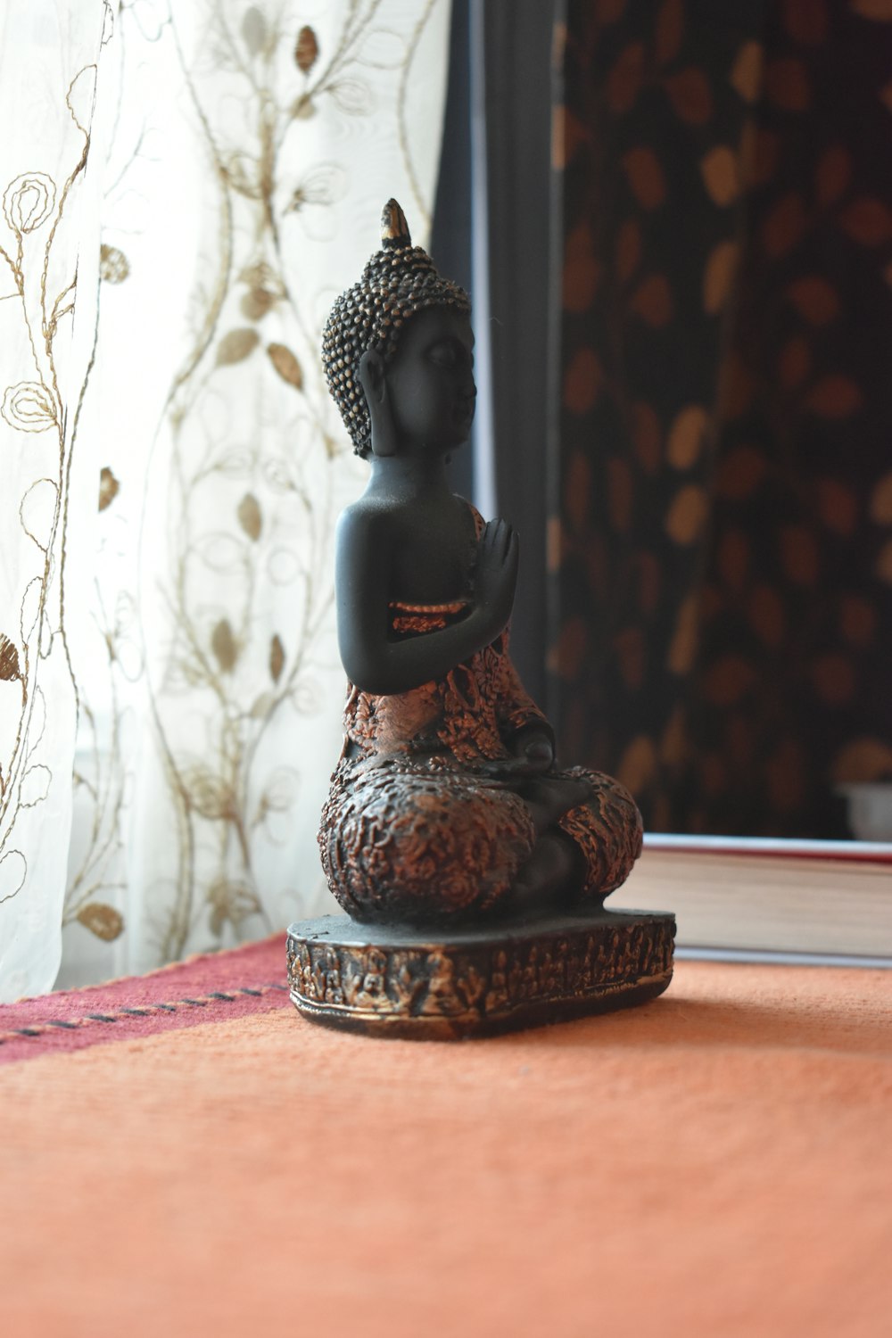 a buddha statue sitting on top of a wooden table