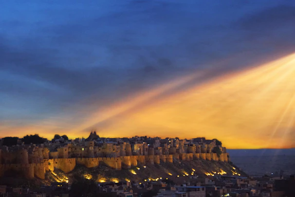 A vibrant sunset view over Hanumant Fort with lush green surroundings.