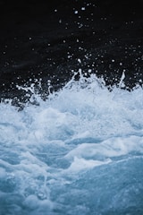 A dynamic scene of water splashing with droplets suspended in the air, creating an energetic and lively atmosphere. The water appears to be churning and frothy, suggesting movement and turbulence.