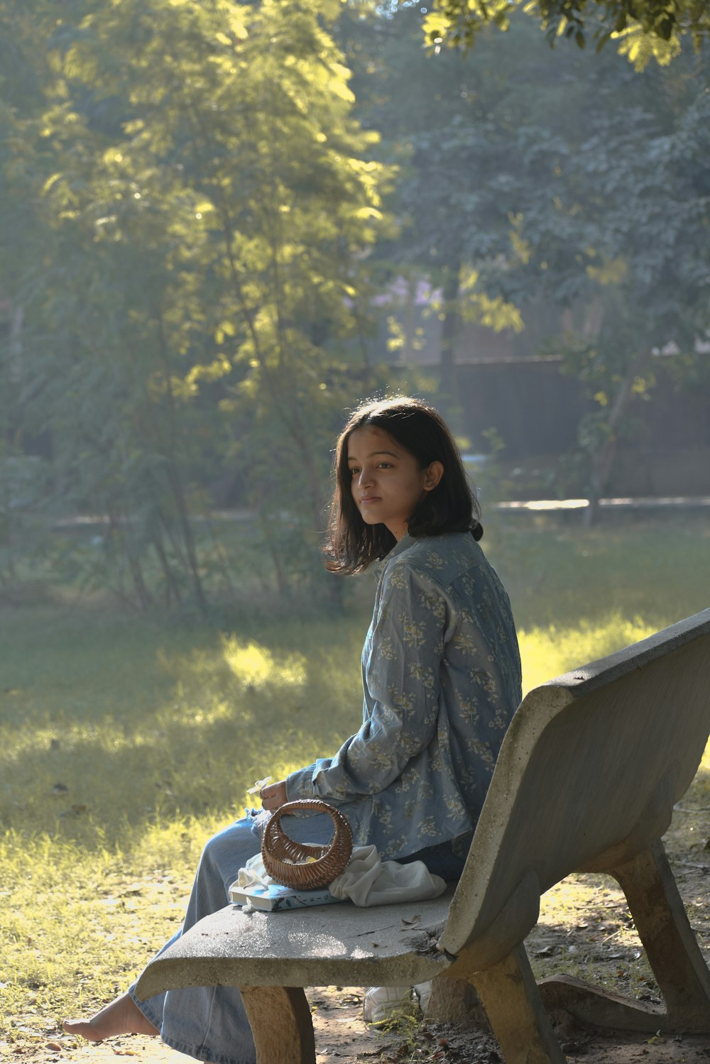 a woman sitting on a bench in a park