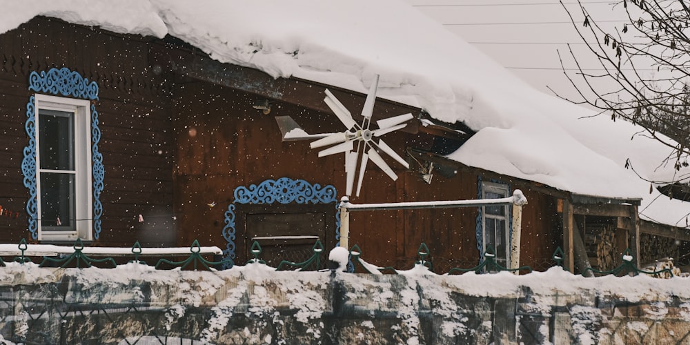 a wooden house with a large snow covered roof
