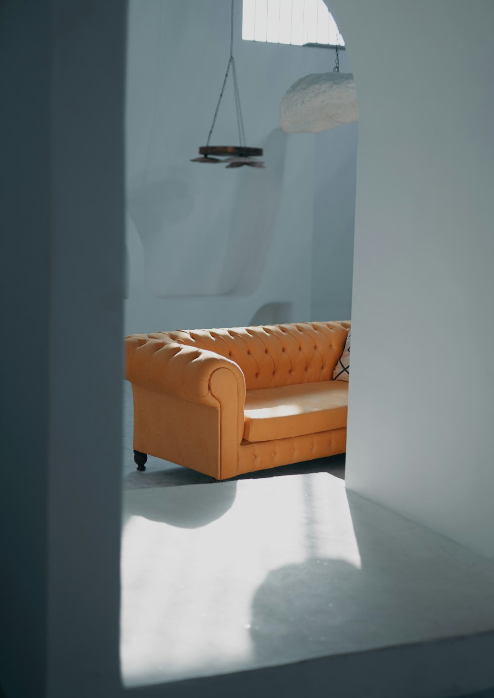 an orange couch sitting in a room next to a window