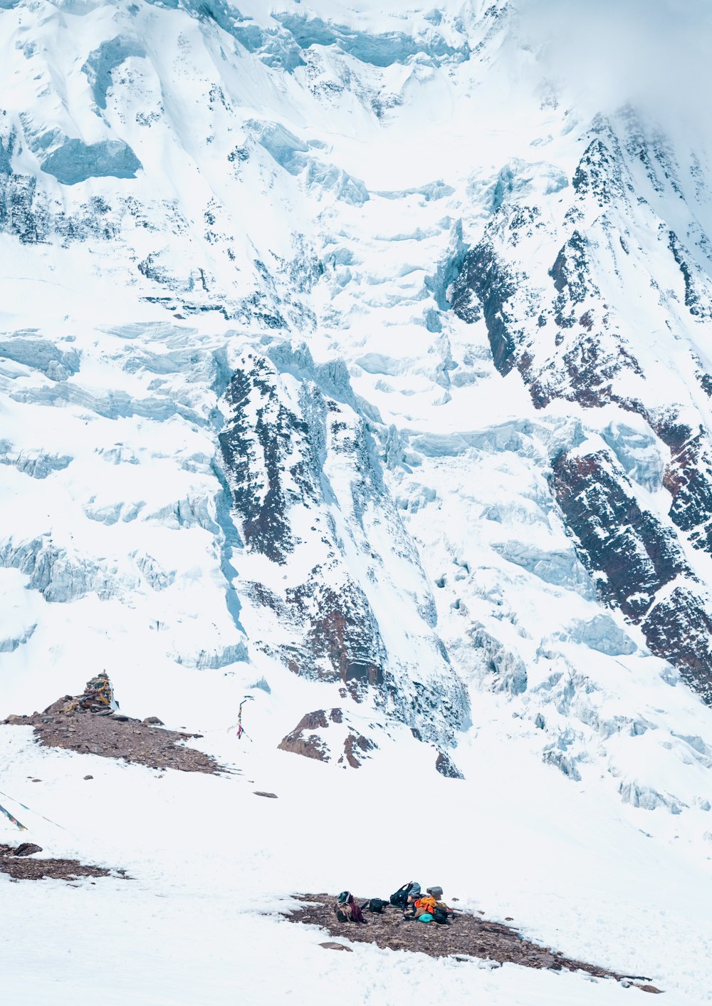 a group of people sitting on top of a snow covered mountain