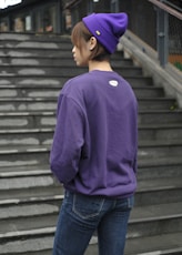 a woman wearing a purple sweatshirt and a purple hat