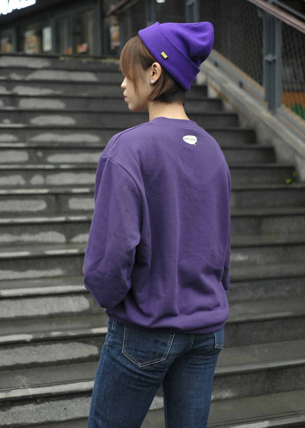 a woman wearing a purple sweatshirt and a purple hat