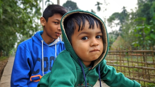 Boys volunteering at a local community garden wearing black and white team hoodies.