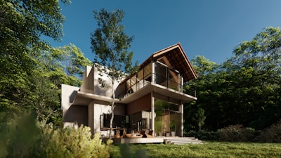 A modern house nestled in a natural setting with large windows overlooking a forest.