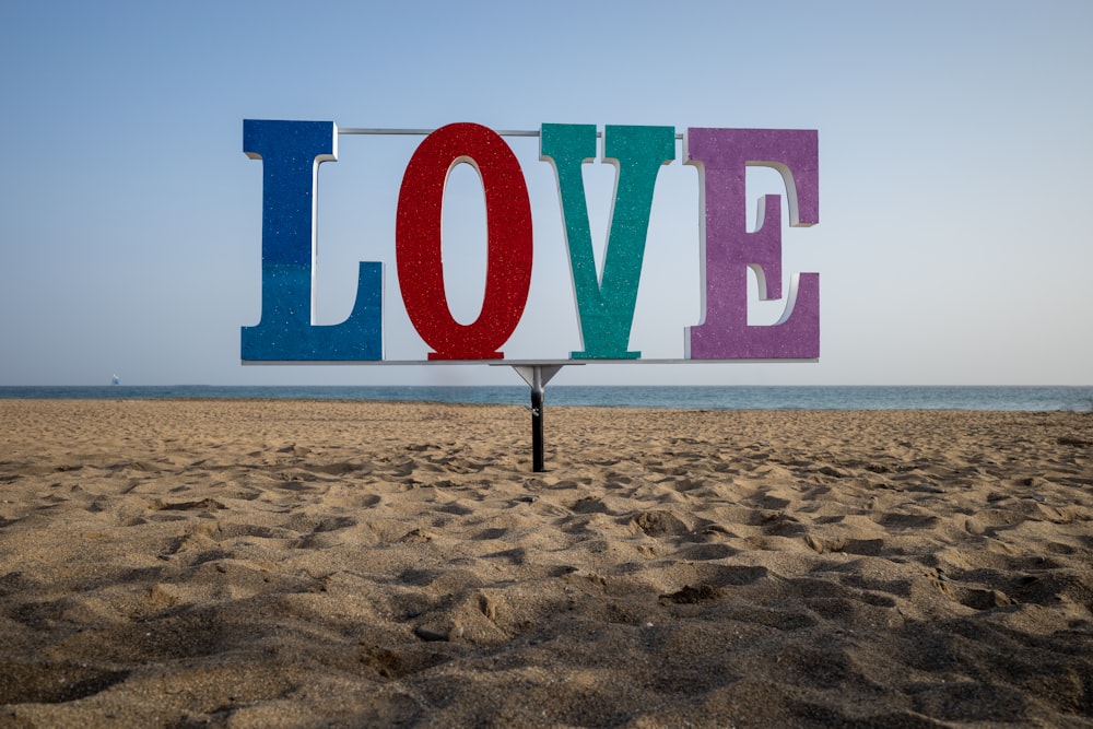 a sign that says love on a beach