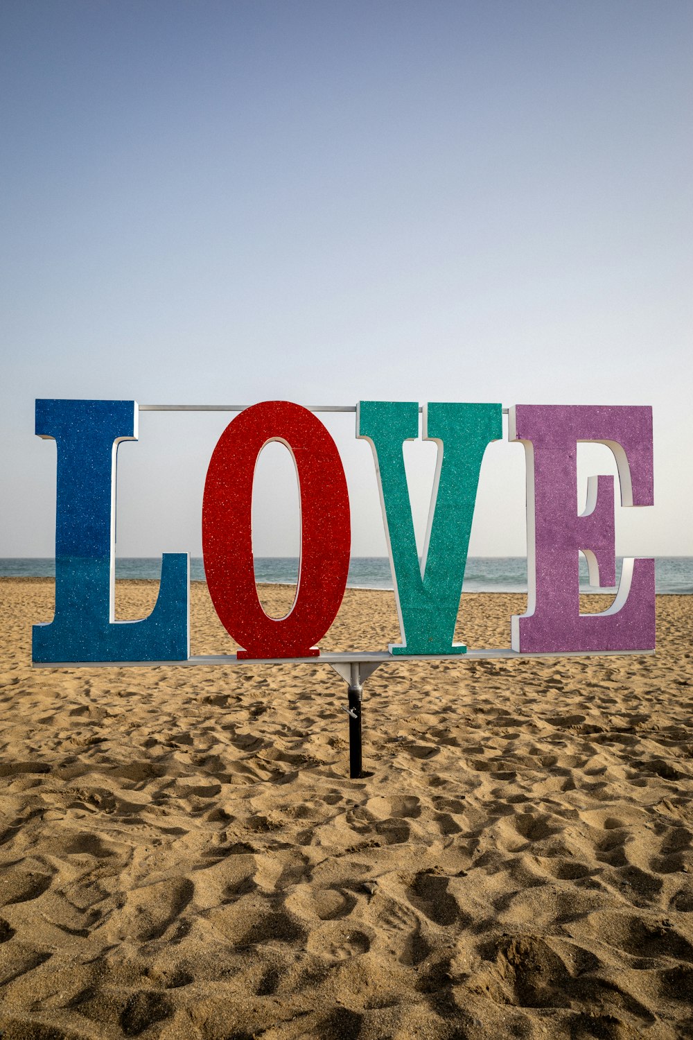 a sign that says love on a beach