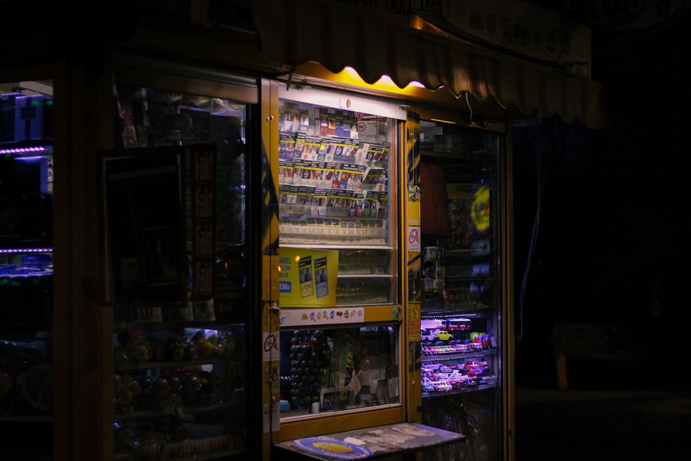 a vending machine sitting outside of a store at night