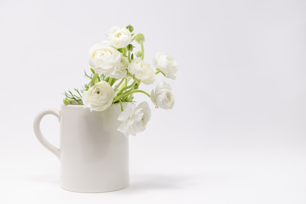 a white vase with white flowers in it