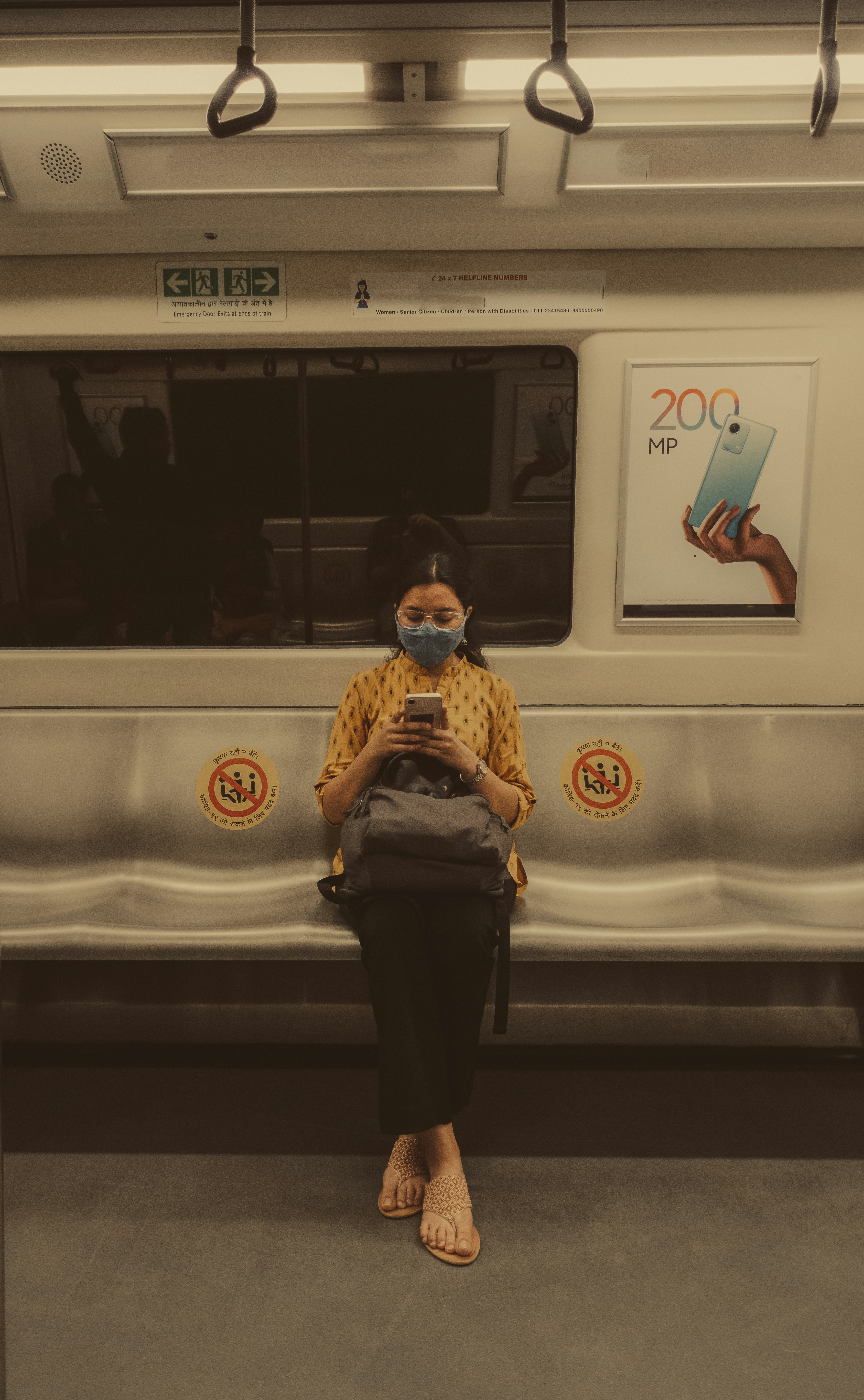 a woman wearing a face mask sitting on a train