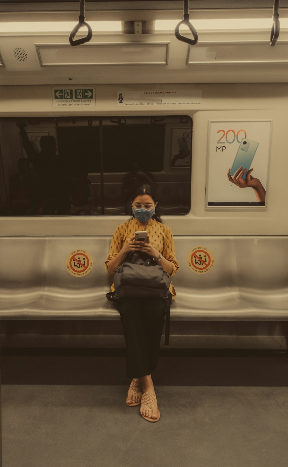 a woman wearing a face mask sitting on a train