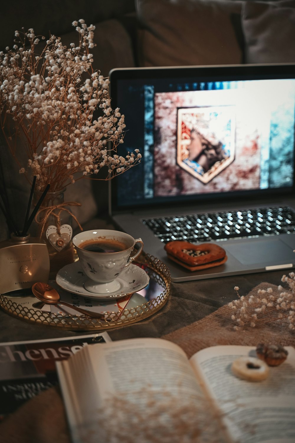 a laptop computer sitting on top of a table next to a cup of coffee