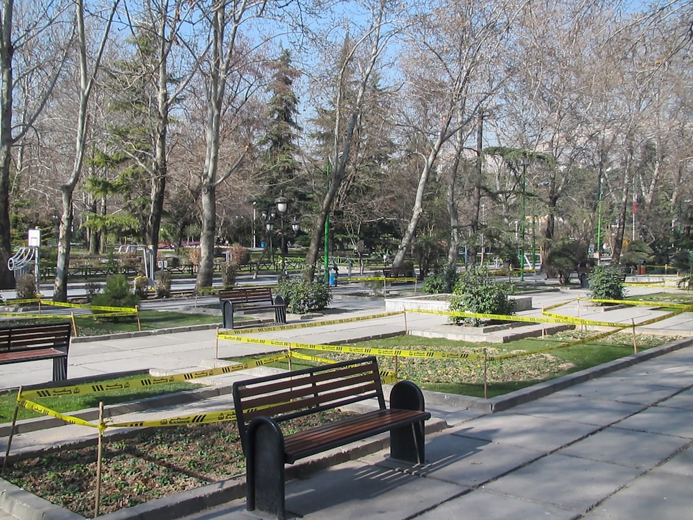 a park with benches and yellow caution tape