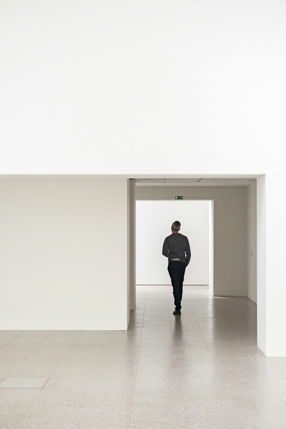 Un uomo sta camminando attraverso una stanza bianca
