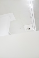 Close-up of skilled hands installing ceiling panels in a minimalist home interior.