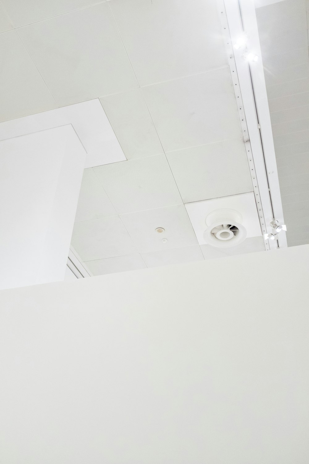 a white room with a ceiling fan and a white wall