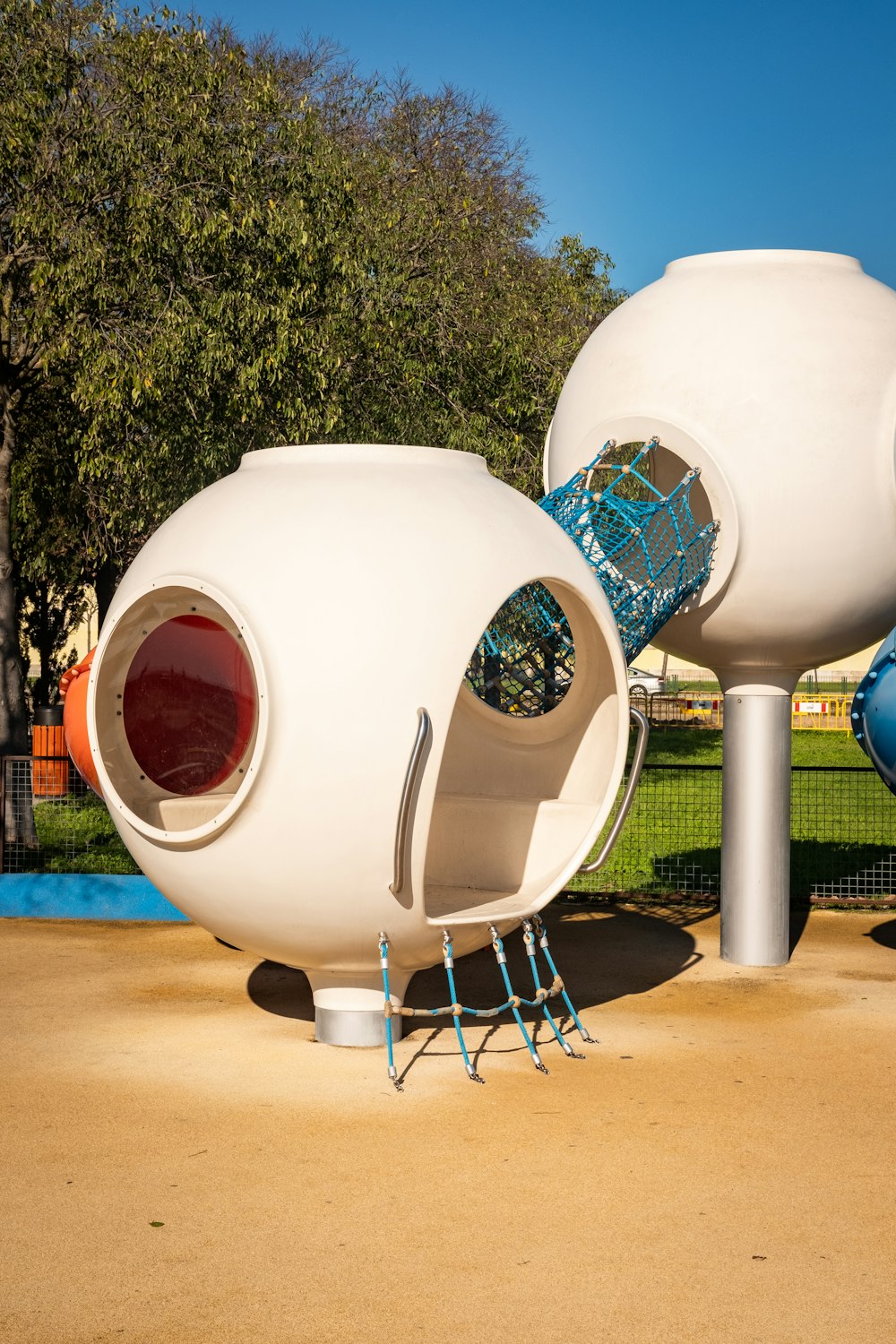 a playground with a large white structure with a red door