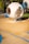 A modern playground structure features a futuristic, spherical design in a neutral, white color. The structure includes circular openings and is connected to a cylindrical tunnel made of blue netting material. The playground area has a soft, rubberized surface with decorative blue lines.